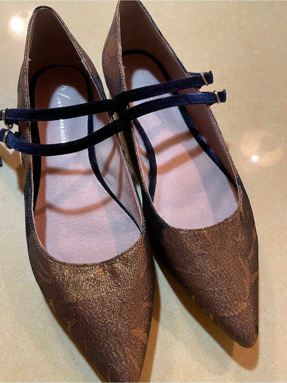 Anthropologie flats. Damask print in gold with navy blue straps.